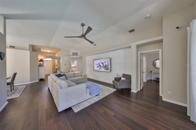 living room featuring arched walkways, visible vents, dark wood-type flooring, and ceiling fan