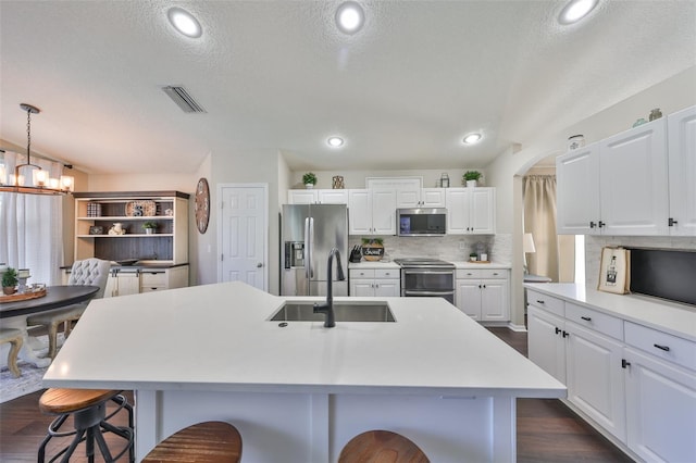 kitchen featuring decorative backsplash, stainless steel appliances, a kitchen bar, and a sink