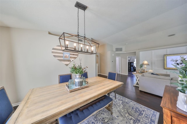 dining area featuring a notable chandelier, wood finished floors, visible vents, and baseboards