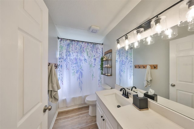 bathroom with shower / bathtub combination with curtain, toilet, vanity, and wood finished floors