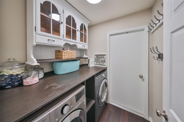 laundry room with dark wood finished floors, cabinet space, and washing machine and clothes dryer