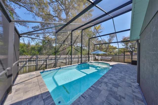 view of swimming pool with a patio area, glass enclosure, a pool with connected hot tub, and a fenced backyard