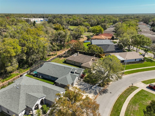 drone / aerial view featuring a residential view and a wooded view