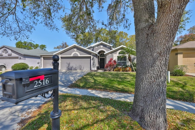 ranch-style house with stucco siding, a front yard, concrete driveway, and an attached garage