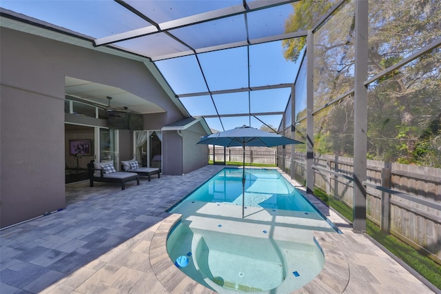 view of pool featuring a patio, an in ground hot tub, a lanai, and fence