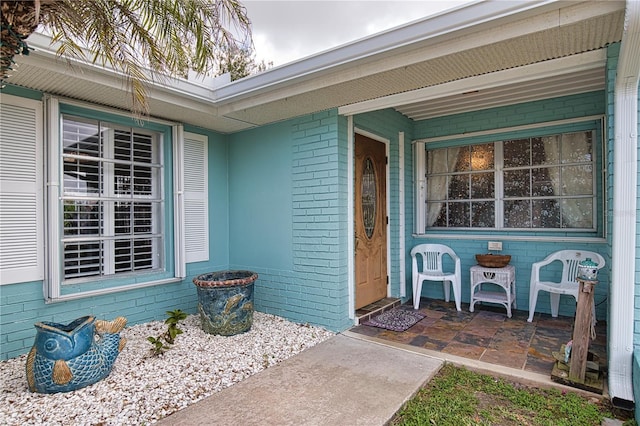 doorway to property featuring brick siding