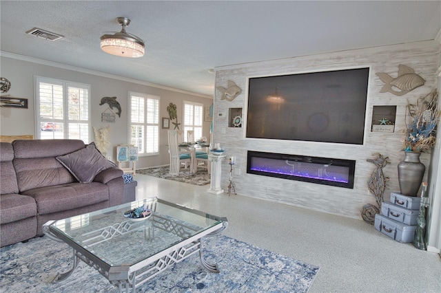 living room featuring visible vents, a textured ceiling, a glass covered fireplace, and ornamental molding