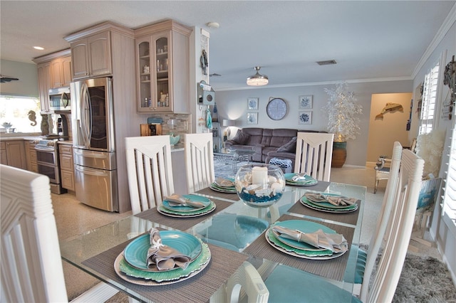 dining space with visible vents, light colored carpet, and crown molding