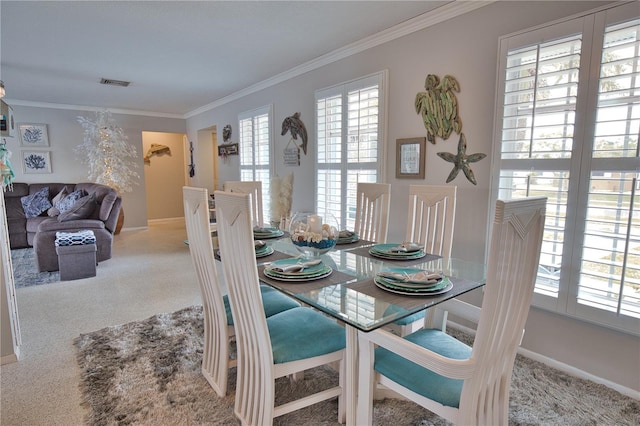 carpeted dining space featuring visible vents, baseboards, and ornamental molding