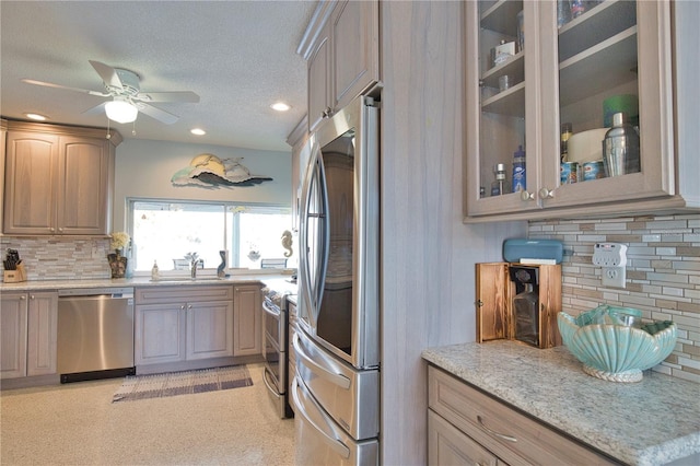 kitchen with tasteful backsplash, glass insert cabinets, stainless steel appliances, a textured ceiling, and a ceiling fan