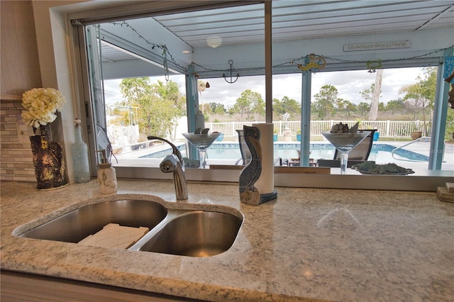 interior details with a sink and light stone countertops