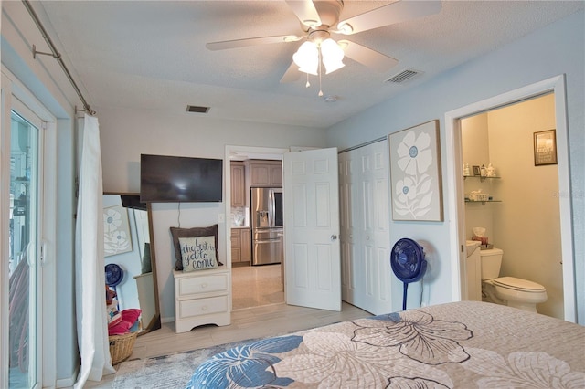 bedroom featuring ensuite bath, visible vents, a textured ceiling, and stainless steel refrigerator with ice dispenser