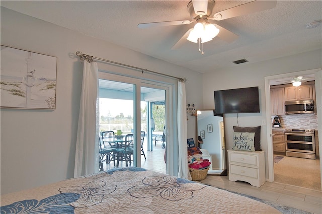 bedroom with access to outside, a ceiling fan, visible vents, and a textured ceiling