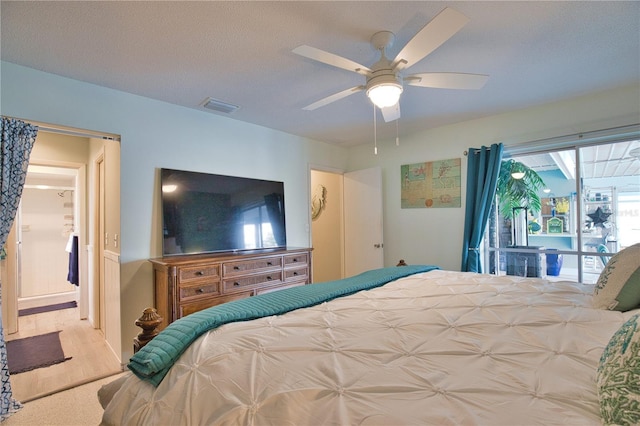 bedroom with visible vents, a textured ceiling, and a ceiling fan