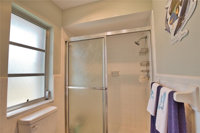 bathroom featuring toilet and a shower stall