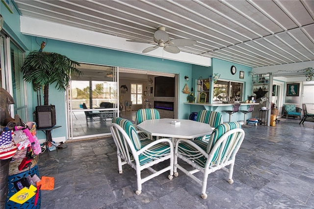 exterior space with a ceiling fan and stone finish floor