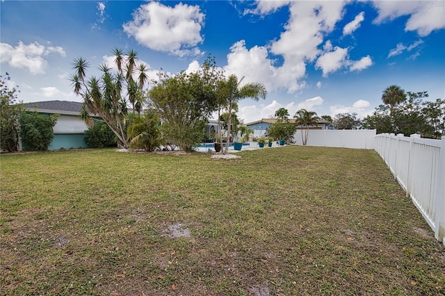 view of yard featuring an outdoor pool and a fenced backyard