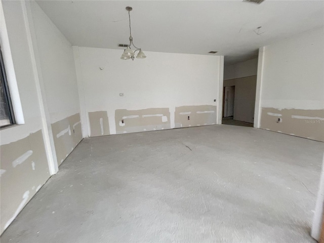 spare room featuring an inviting chandelier