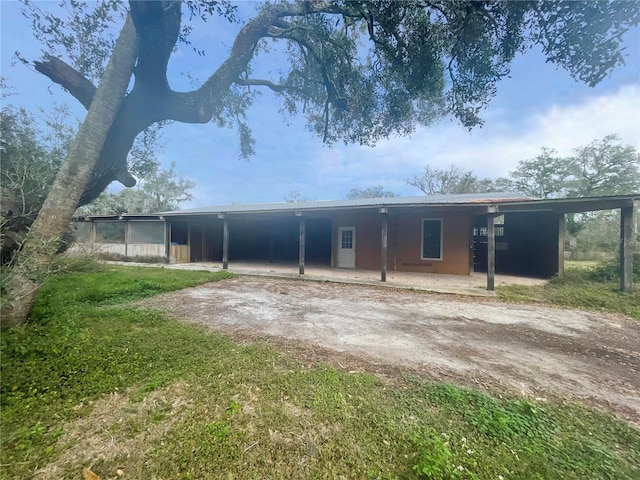 back of property featuring an attached carport and driveway