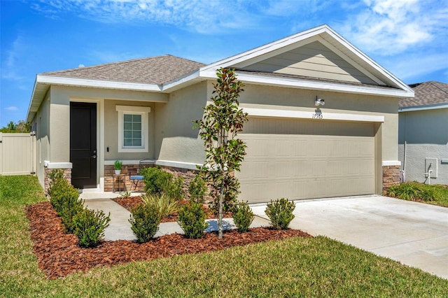 view of front of property featuring concrete driveway, an attached garage, stone siding, and stucco siding