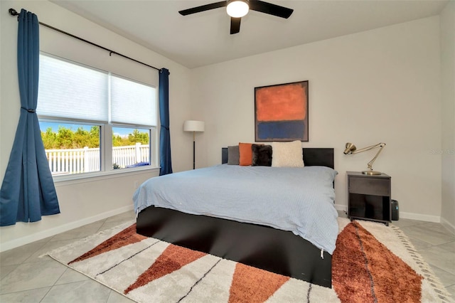 bedroom with tile patterned flooring, a ceiling fan, and baseboards