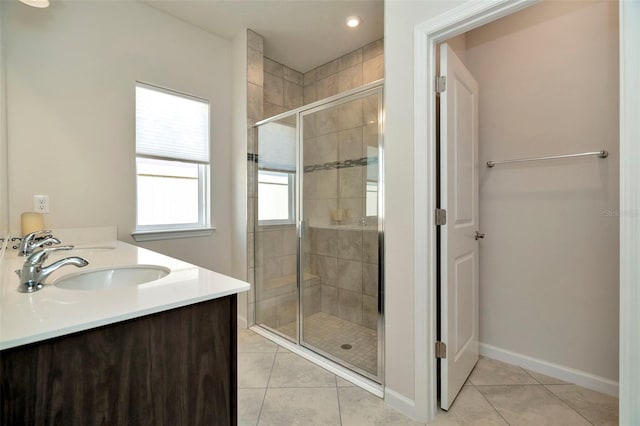 full bathroom with tile patterned flooring, baseboards, a stall shower, and a sink