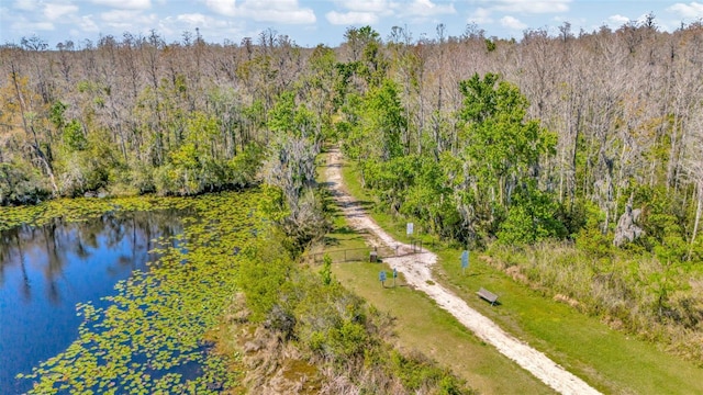 drone / aerial view featuring a water view and a wooded view