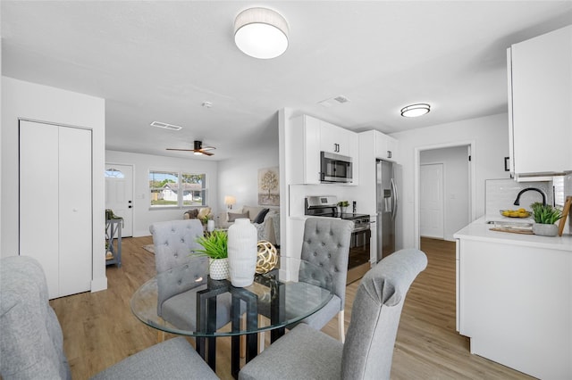 dining area featuring a ceiling fan, visible vents, and light wood-style flooring