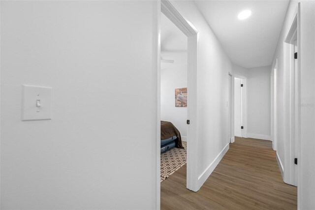 hall featuring wood finished floors and baseboards