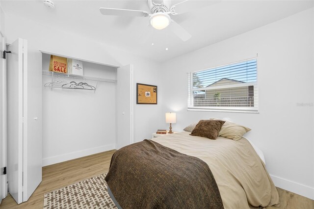 bedroom with a closet, light wood-type flooring, a ceiling fan, and baseboards