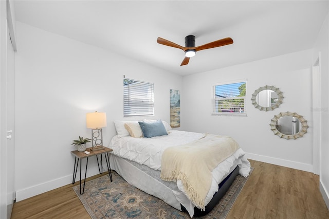 bedroom with wood finished floors, a ceiling fan, and baseboards