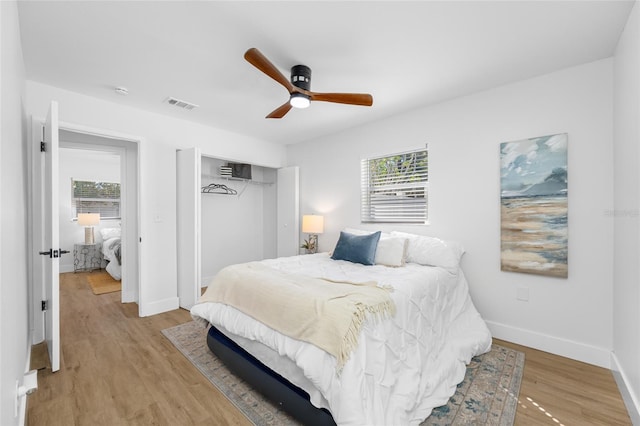 bedroom featuring multiple windows, light wood-type flooring, a closet, and visible vents