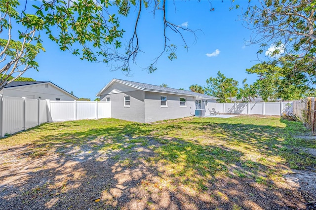 back of house with a yard, a fenced backyard, and stucco siding