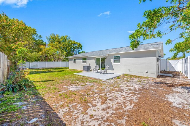 back of house featuring a fenced backyard, central air condition unit, a lawn, a gate, and a patio area