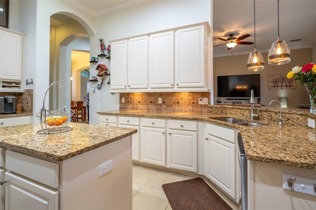 kitchen featuring a ceiling fan, backsplash, and ornamental molding