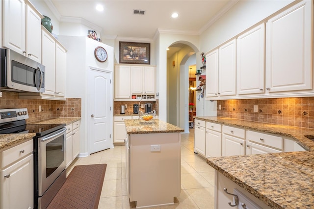 kitchen featuring stainless steel appliances, visible vents, ornamental molding, and white cabinets