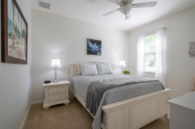 bedroom with visible vents, light colored carpet, a ceiling fan, and baseboards