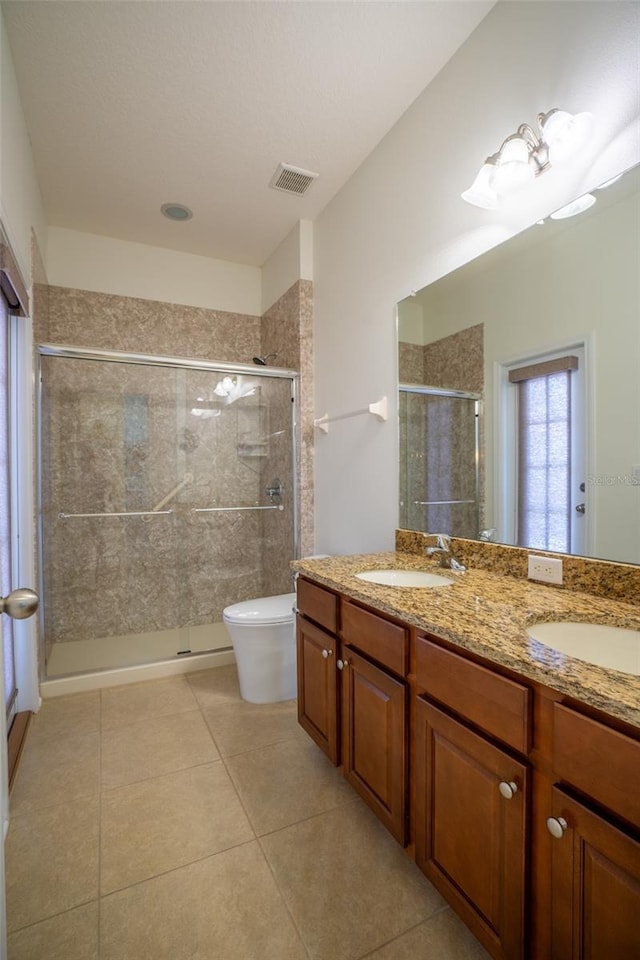 full bath with tile patterned flooring, visible vents, a shower stall, and a sink