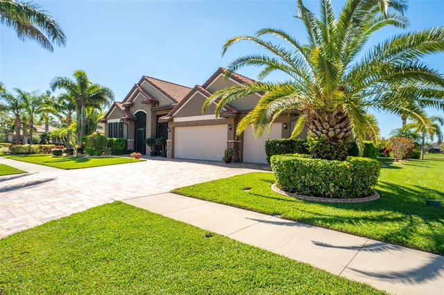 view of front of home featuring stucco siding, driveway, stone siding, a front yard, and a garage