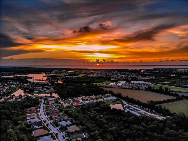 aerial view at dusk featuring a water view