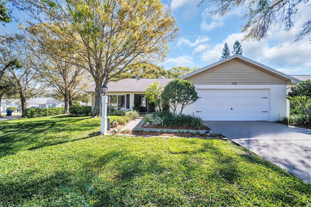 single story home featuring a front lawn, a garage, and driveway