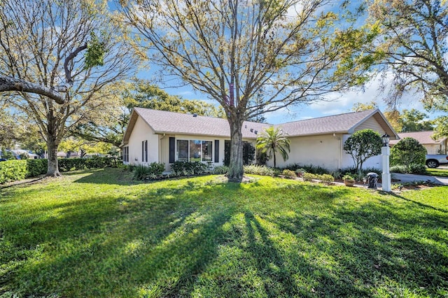 ranch-style home featuring stucco siding and a front yard