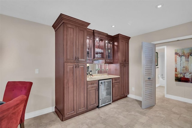 bar featuring beverage cooler, recessed lighting, bar, and baseboards