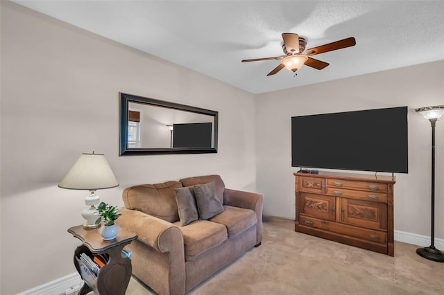 living area featuring baseboards and ceiling fan