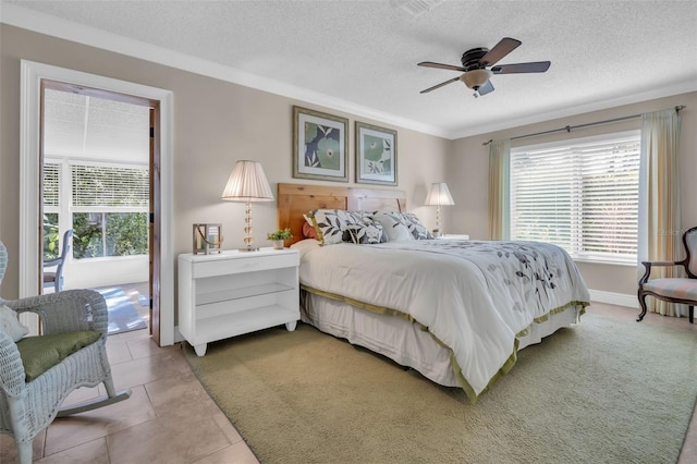 bedroom featuring baseboards, ornamental molding, light tile patterned flooring, a textured ceiling, and a ceiling fan