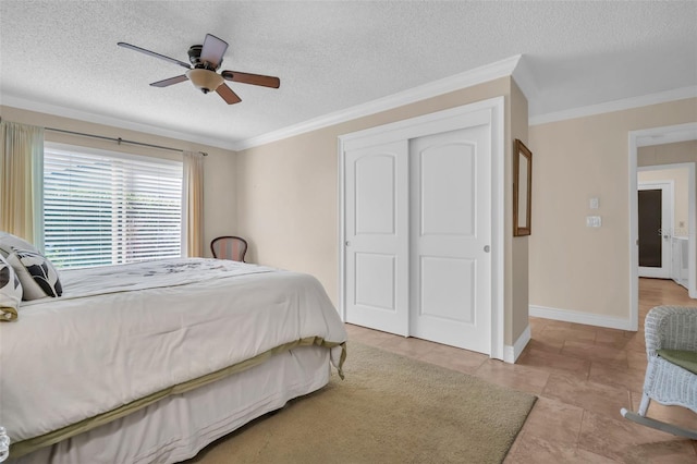 bedroom featuring a textured ceiling, baseboards, a closet, and ornamental molding