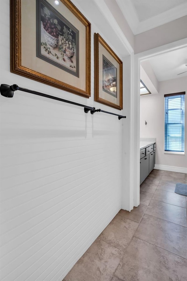 bathroom with baseboards, ornamental molding, and vanity