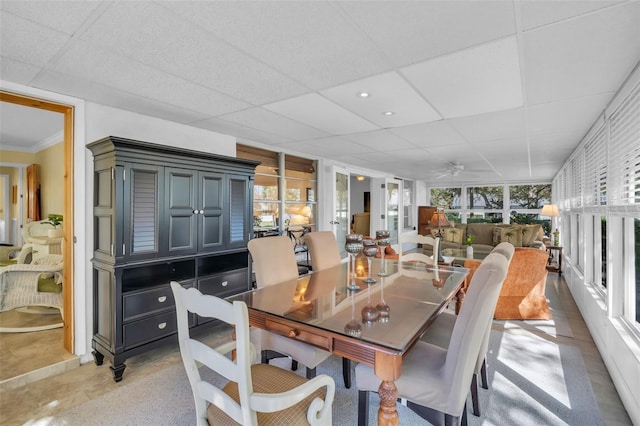 dining room with concrete floors, a paneled ceiling, and a ceiling fan