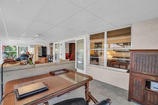 interior space with a drop ceiling and ceiling fan