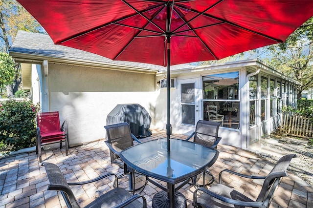 view of patio / terrace featuring area for grilling, outdoor dining area, and a sunroom